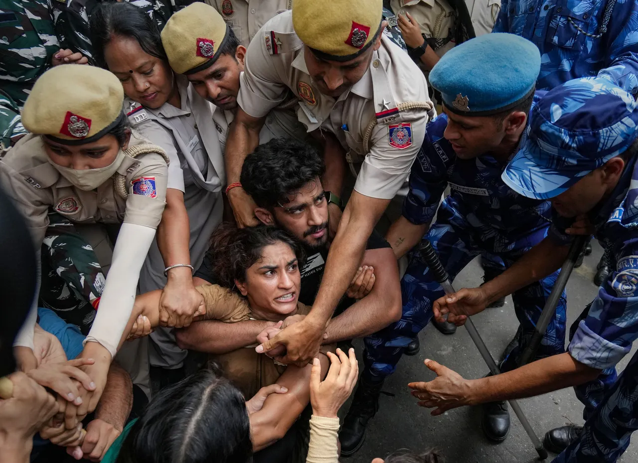 Security personnel detain wrestler Vinesh Phogat during wrestlers' protest march towards new Parliament building, in New Delhi