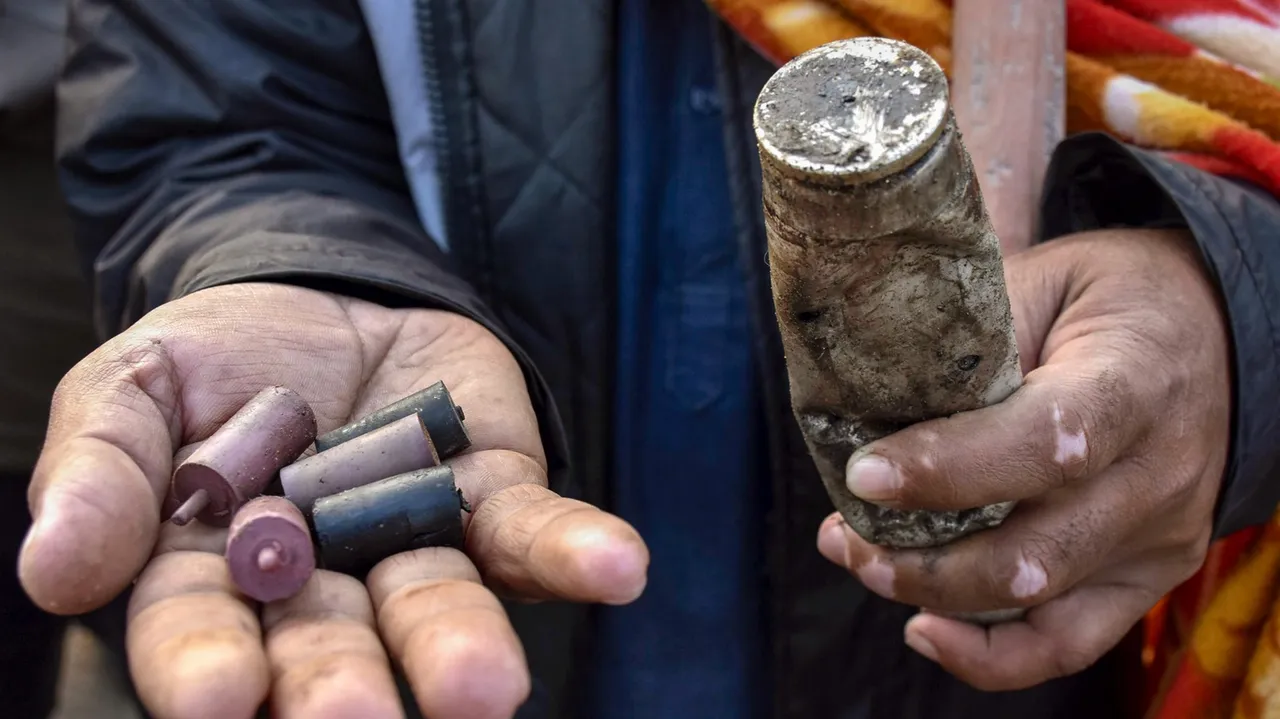 A farmer shows a tear gas shell and rubber bullets fired by the police to disperse protesting farmers gathered at the Punjab-Haryana Shambhu border
