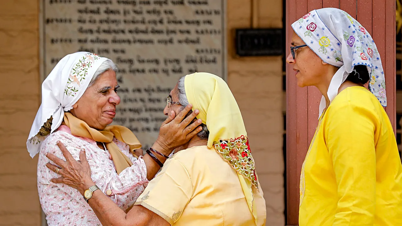 Parsi community women greet each other during a visit to a fire temple on the occasion of 'Navroz', the Parsi New Year, in Ahmedabad, Wednesday