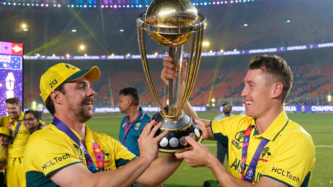 Travis Head and Marnus Labuschagne pose for photographs with the trophy as they celebrate after winning the ICC Men’s Cricket World Cup 2023 finals at the Narendra Modi Stadium, in Ahmedabad, Sunday, Nov. 19, 2023.