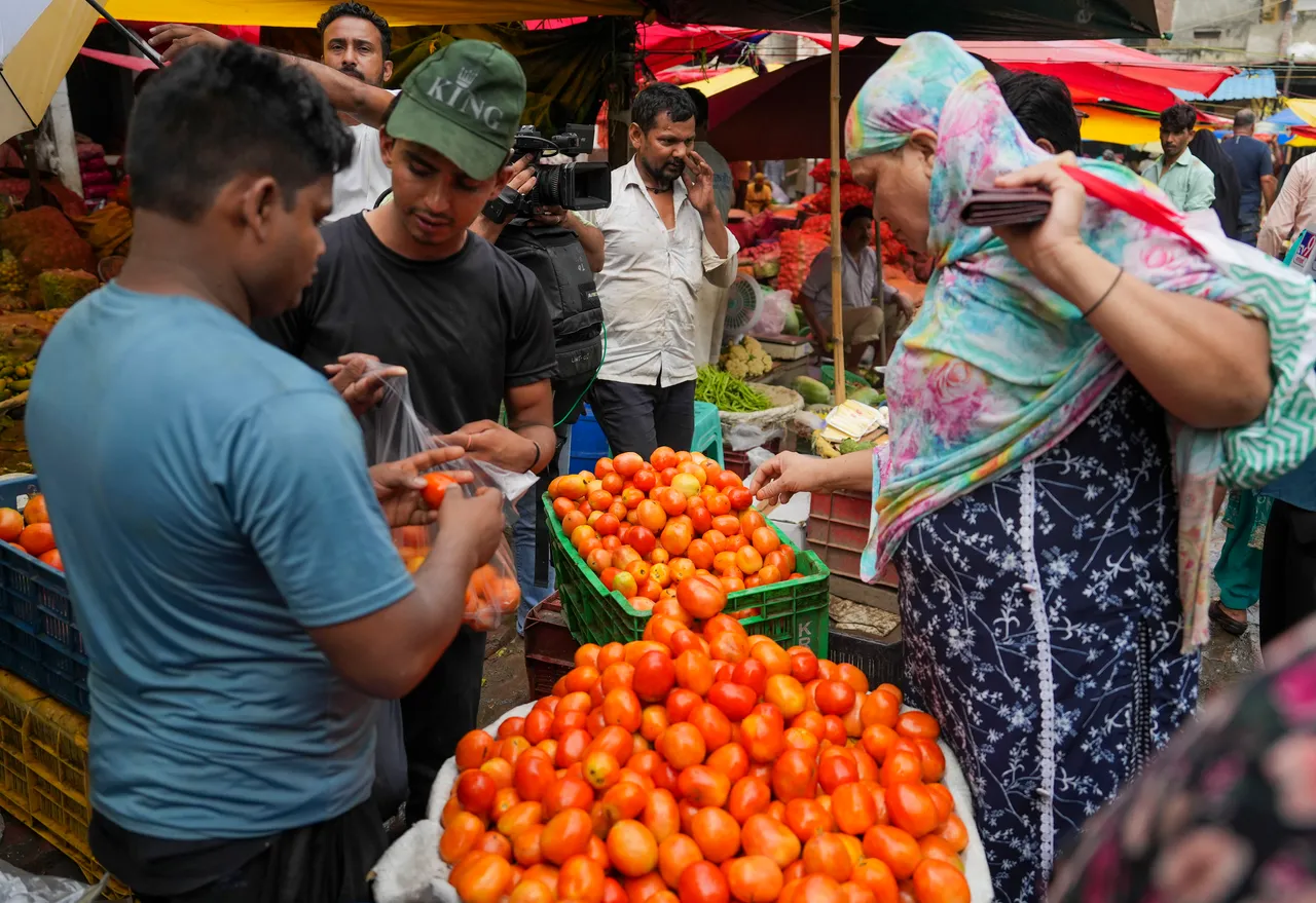 A woman purchases tomato from a vendor in New Delhi