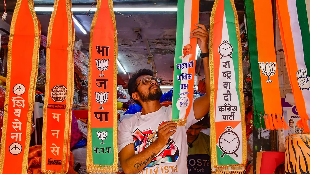 A man arranges scarves of political parties at a shop, ahead of Lok Sabha elections, in Mumbai