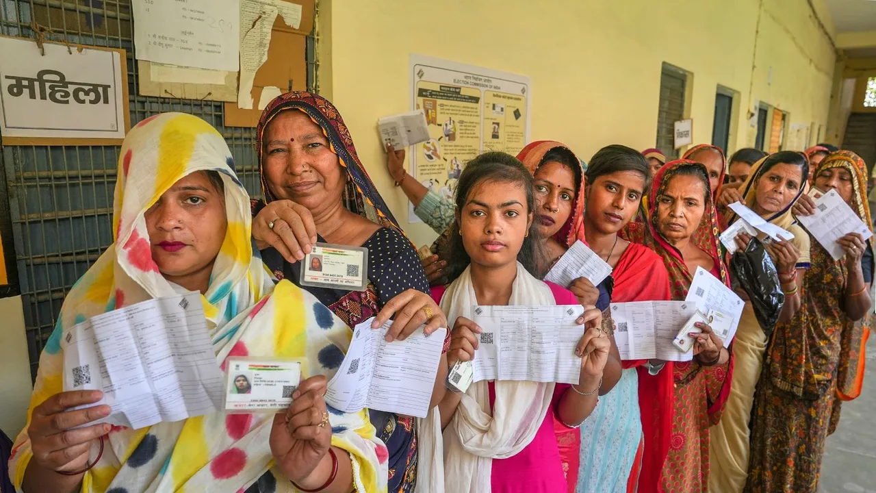 People wait to cast their vote for the third phase of Lok Sabha elections, in Hathras, Uttar Pradesh, Tuesday, May 7, 2024