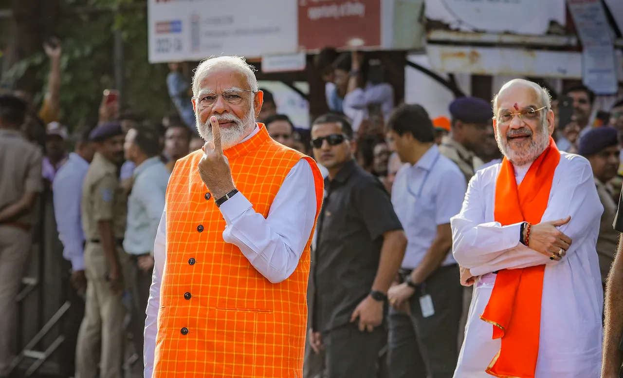 Prime Minister Narendra Modi arrives to cast his vote for the third phase of Lok Sabha elections as Union Home Minister Amit Shah looks on, in Ahmedabad, Tuesday, May 7, 2024.