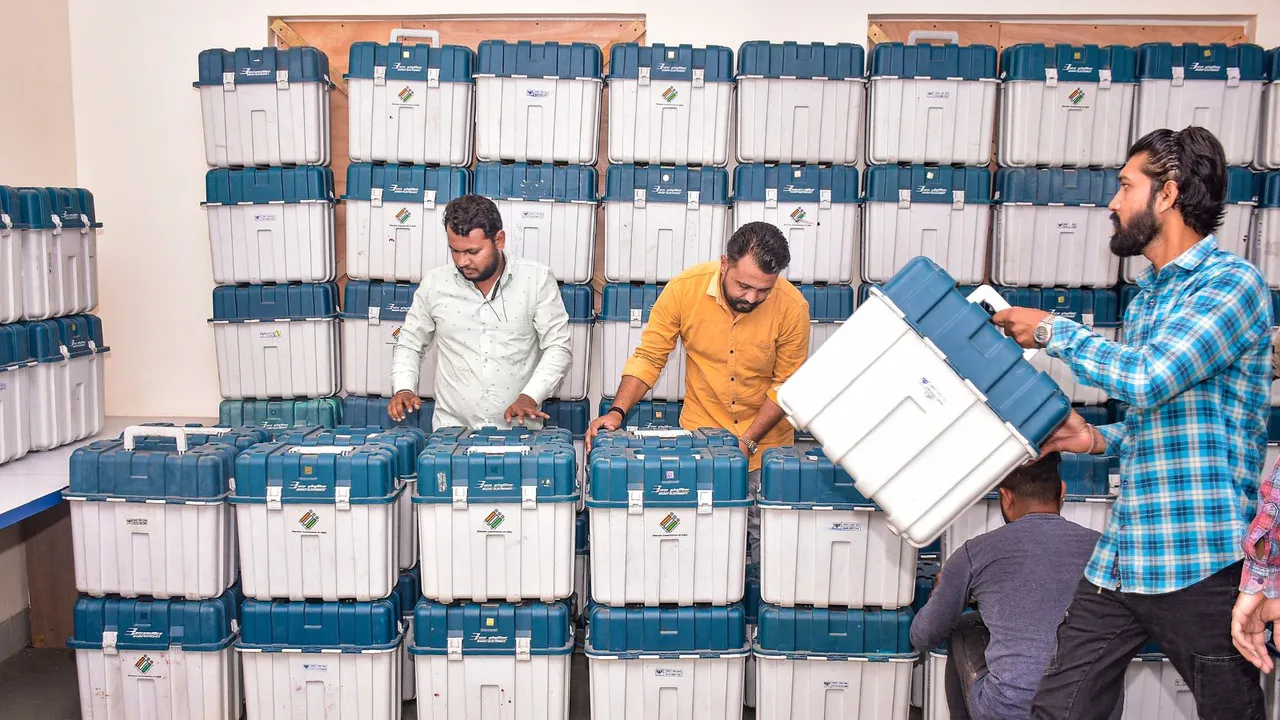 Workers unload EVMs, to be kept in a strong room, ahead of Lok Sabha elections, in Surat, Friday, April 5, 2024