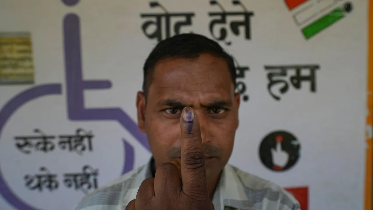 A voter shows his finger marked with indelible ink after casting vote for the second phase of Lok Sabha elections