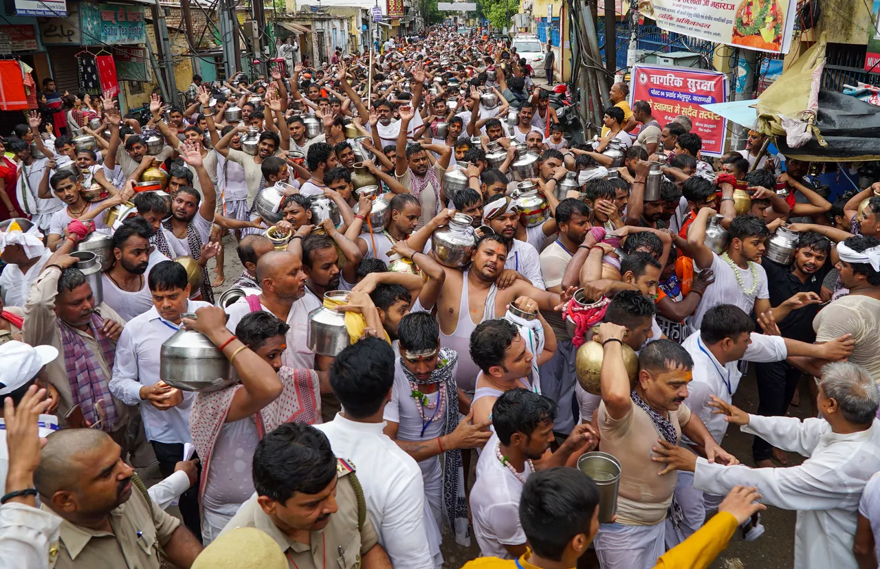 Devotees move towards the Kashi Vishwanath Temple to perform Jalabhishek on the occasion of the first Somwar (Monday) of the holy month of 'Shravan', in Varanasi