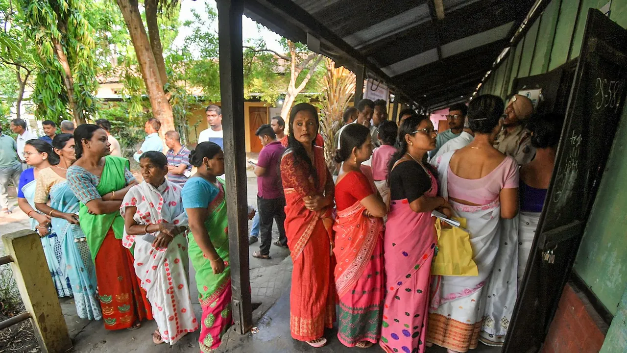People wait to cast their votes for the second phase of Lok Sabha elections, in Nagaon district, Assam, Friday, April 26, 2024