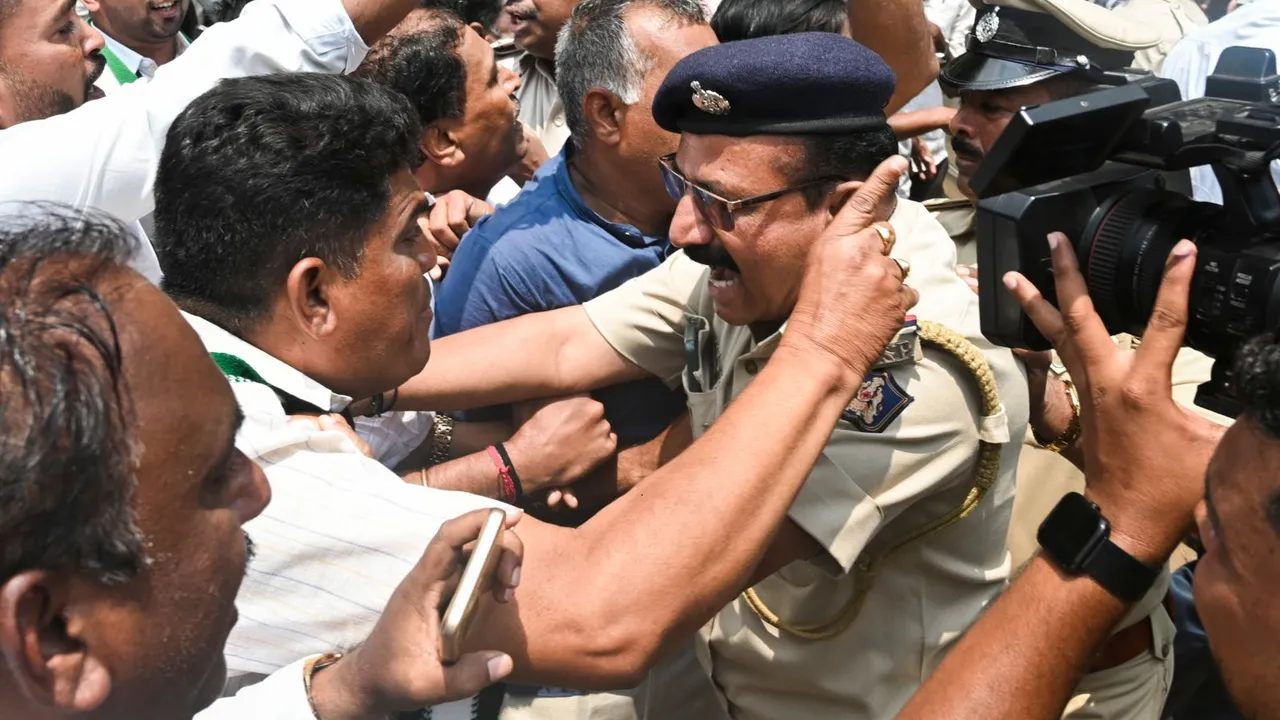Police personnel try to pacify the situation following a scuffle between workers of Congress and JD(S) over the alleged sex scandal involving JD(S) MP Prajwal Revanna, in Hubballi, Tuesday, April 30, 2024