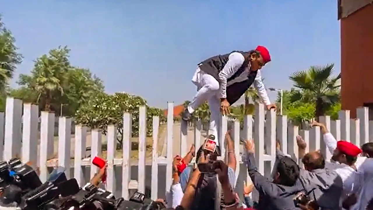 Samajwadi Party chief Akhilesh Yadav climbs a gate while trying to enter Jai Prakash Narayan International Center