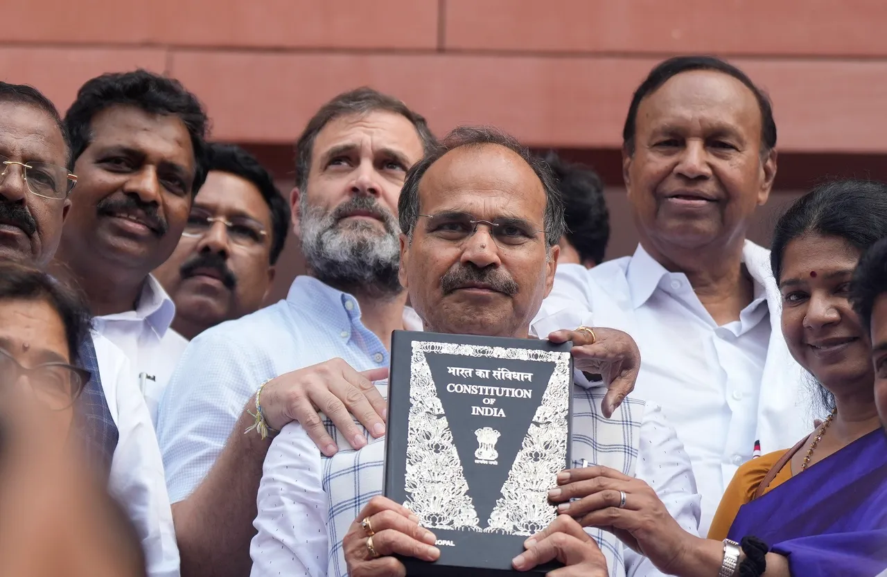 Congress MP Adhir Ranjan Chowdhury, holding the Constitution of India, with party MP Rahul Gandhi and other Parliamentarians walks towards the new Parliament building, in New Delhi