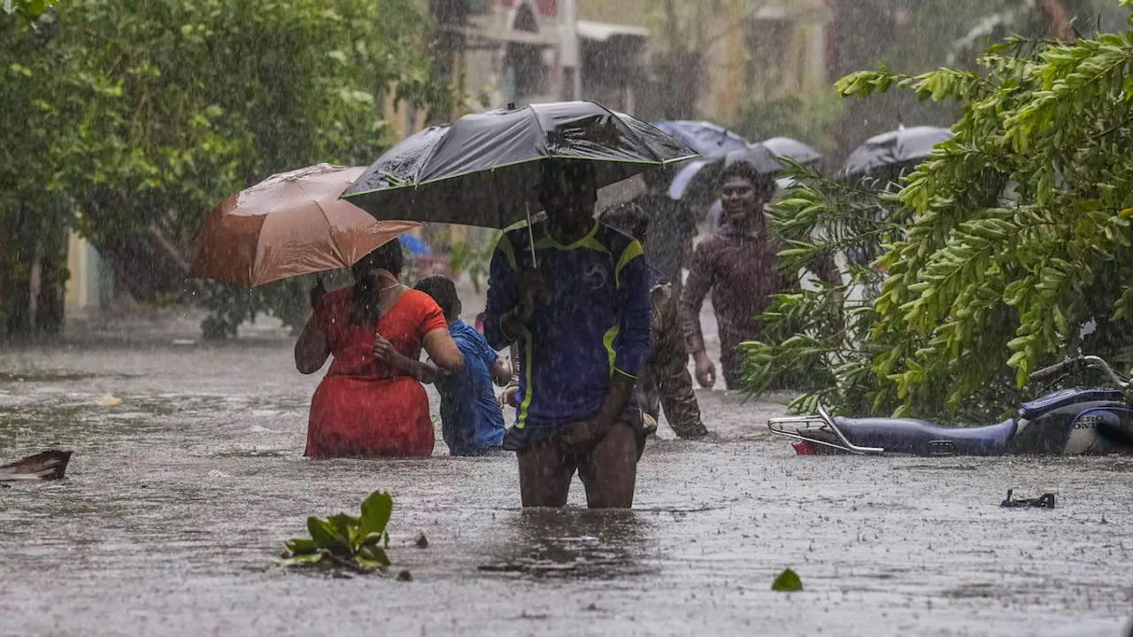 People wade through a waterlogged road during heavy rain owing to Cyclone Michaung, in Chennai, Monday, Dec. 4, 2023.