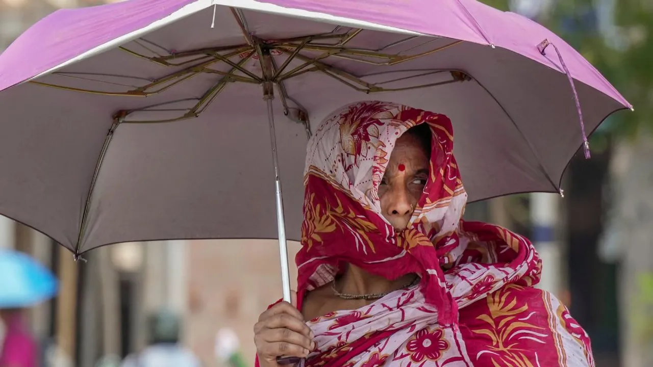 A pedestrian holding umbrella to protect herself from scorching sun on a hot summer day, in Kolkata, Tuesday, April 30, 2024. 