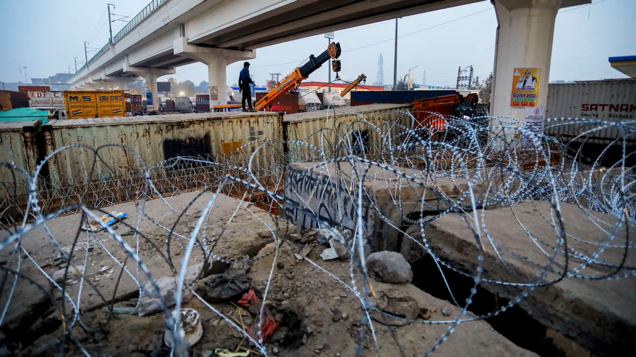 Police install barricades and concertina wires near the Tikri border in view of farmers' 'Delhi Chalo' march, near New Delhi, Tuesday, Feb. 13, 2024.