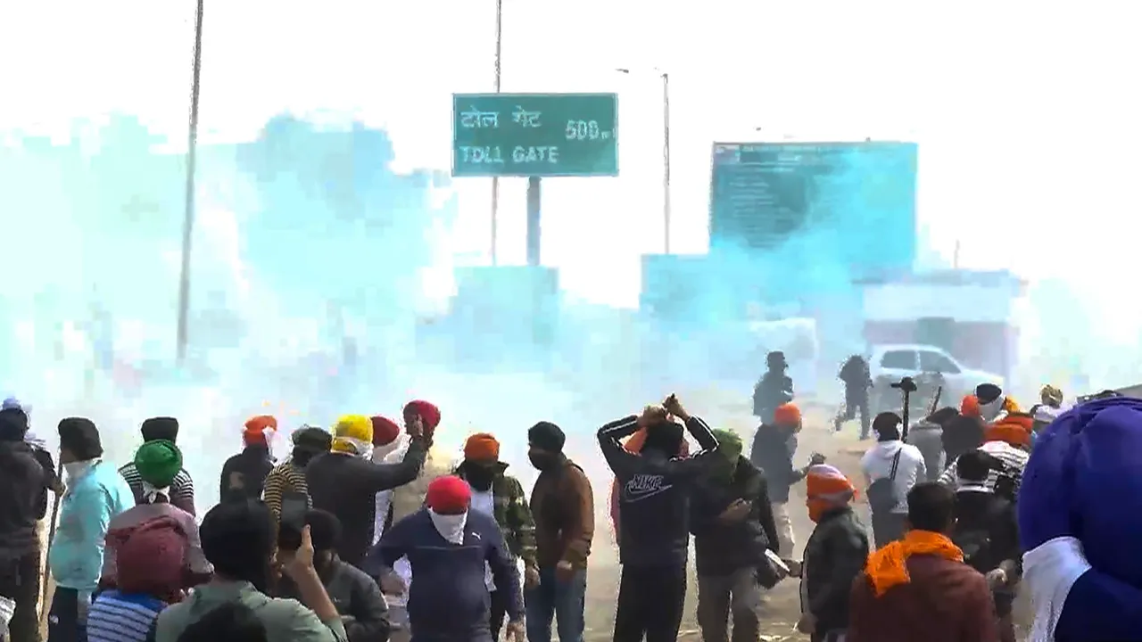 Farmers move away after police fired teargas shell to disperse them during their 'Delhi Chalo' march at Punjab-Haryana Shambhu border, near Ambala