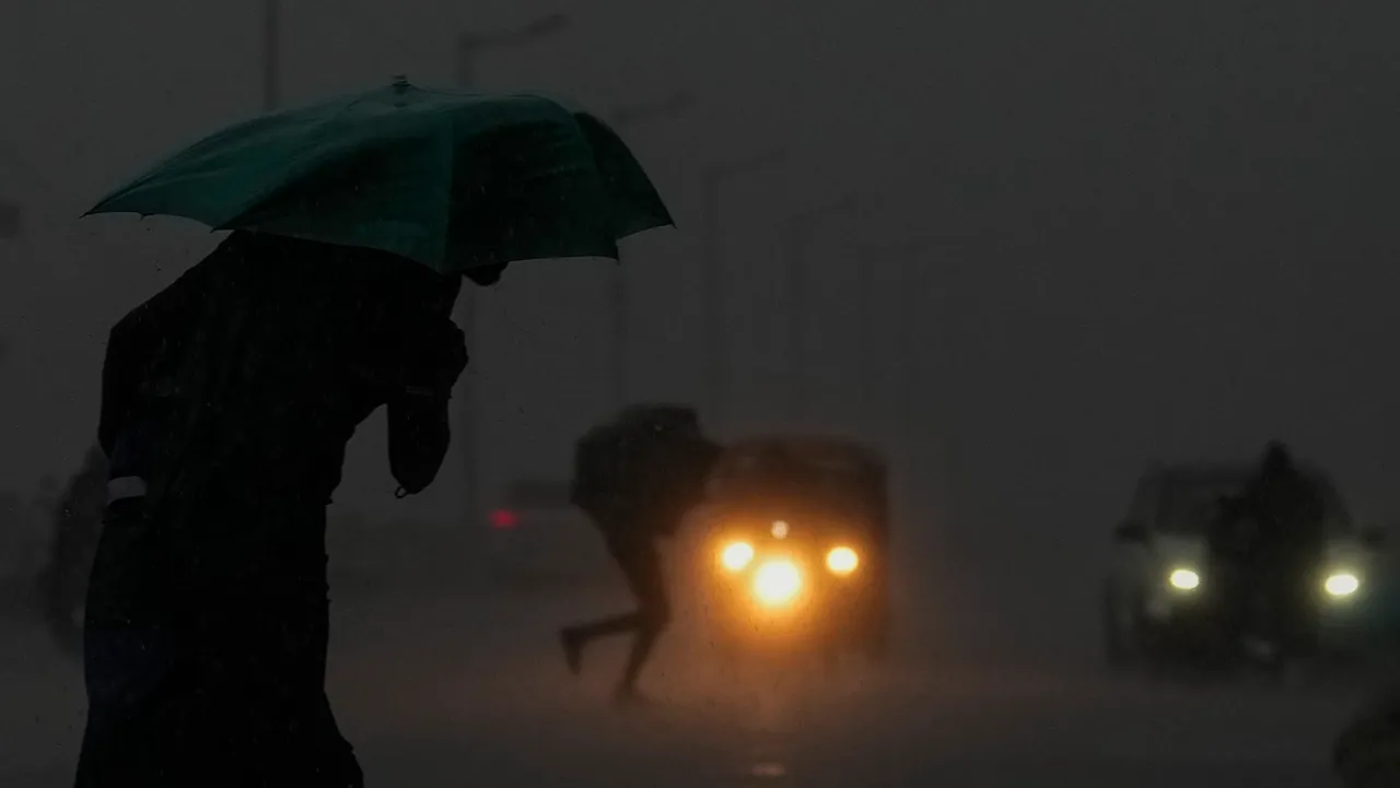Commuters on a road during heavy rain owing to Cyclone Michaung, in Chennai