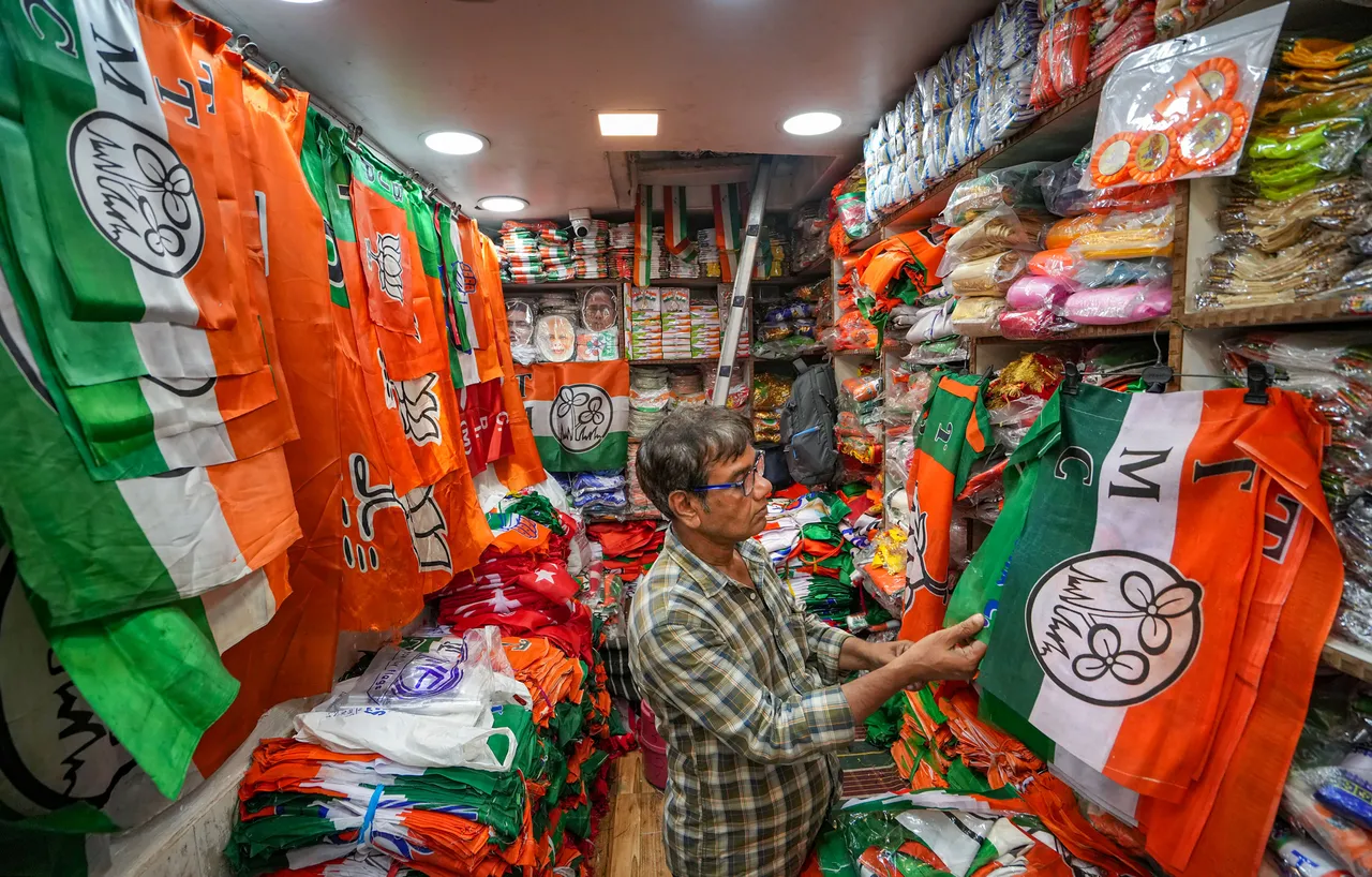 A worker arranges flags of Trinamool Congress at a shop for sale ahead of the West Bengal Panchayat elections, in Kolkata