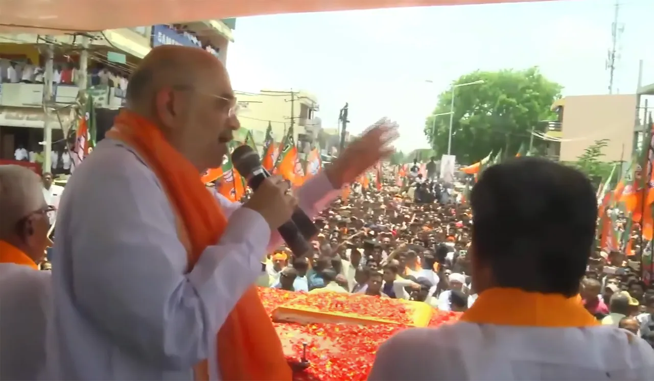 Union Home Minister and senior BJP leader Amit Shah addresses supporters during a roadshow ahead of Karnataka Assembly elections, in Tumkur