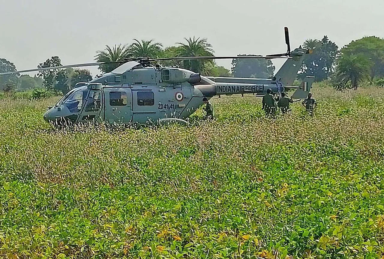 Locals gather near an Indian Air Force (IAF) chopper after an emergency landing in the fields at Dungariya, in Bhopal district