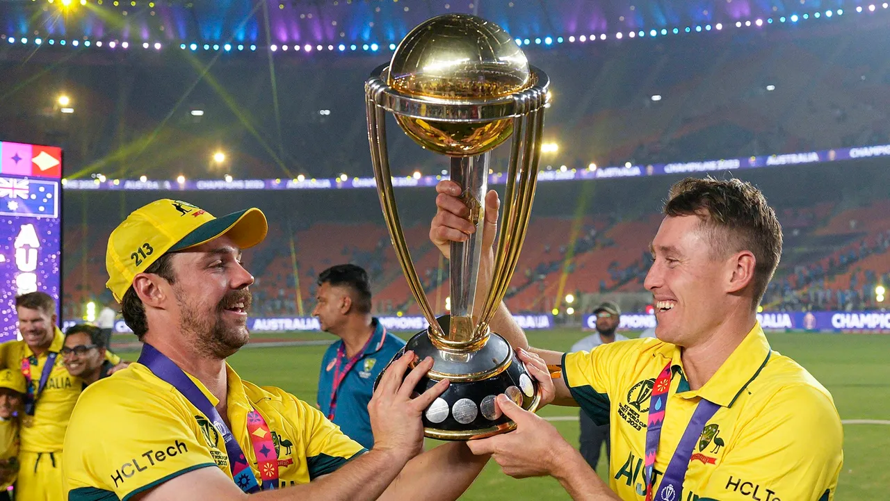 Australian players Travis Head and Marnus Labuschagne pose for photographs with the trophy as they celebrate after winning the ICC Men’s Cricket World Cup 2023 finals