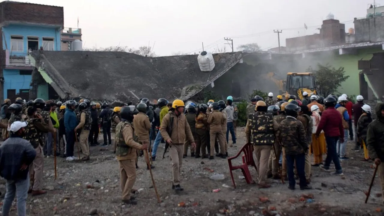 Police officers stand guard during a demolition drive in Haldwani in Uttarakhand on February 8