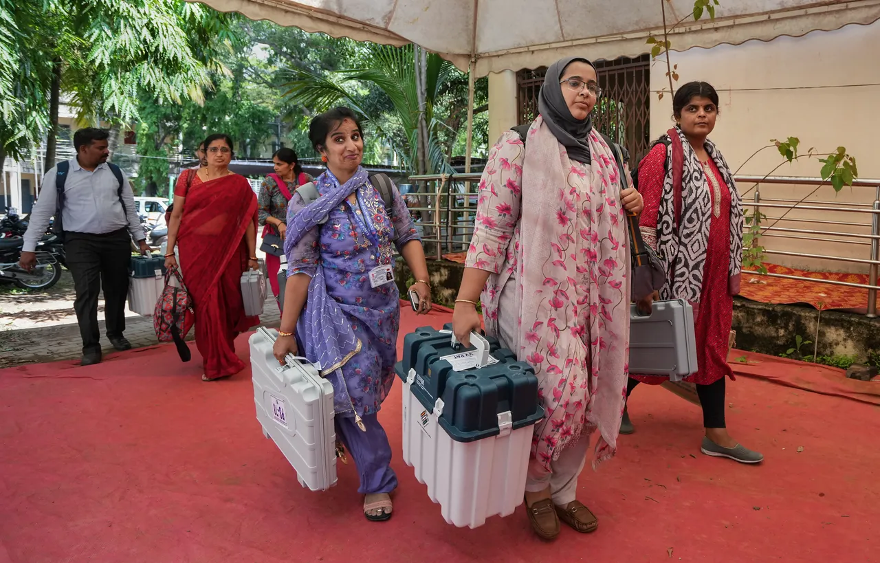 Polling officials leave for their respective polling booths after collecting EVMs and other voting materials ahead of the Karnataka Assembly elections, in Bengaluru