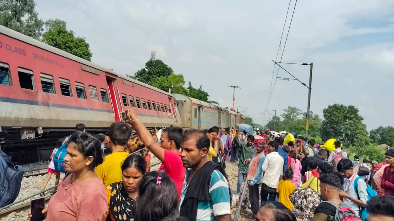 Passengers and locals near the derailed coaches of the Dibrugarh Express train after an accident, in Gonda district, Thursday, July 18, 2024.