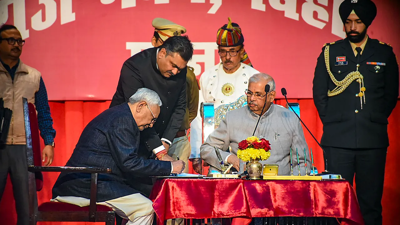 Nitish Kumar signs documents after taking oath as Bihar CM, as the state Governor Rajendra Arlekar looks on, during the swearing-in ceremony of new state government, at Raj Bhavan in Patna, Sunday, Jan. 28, 2024.
