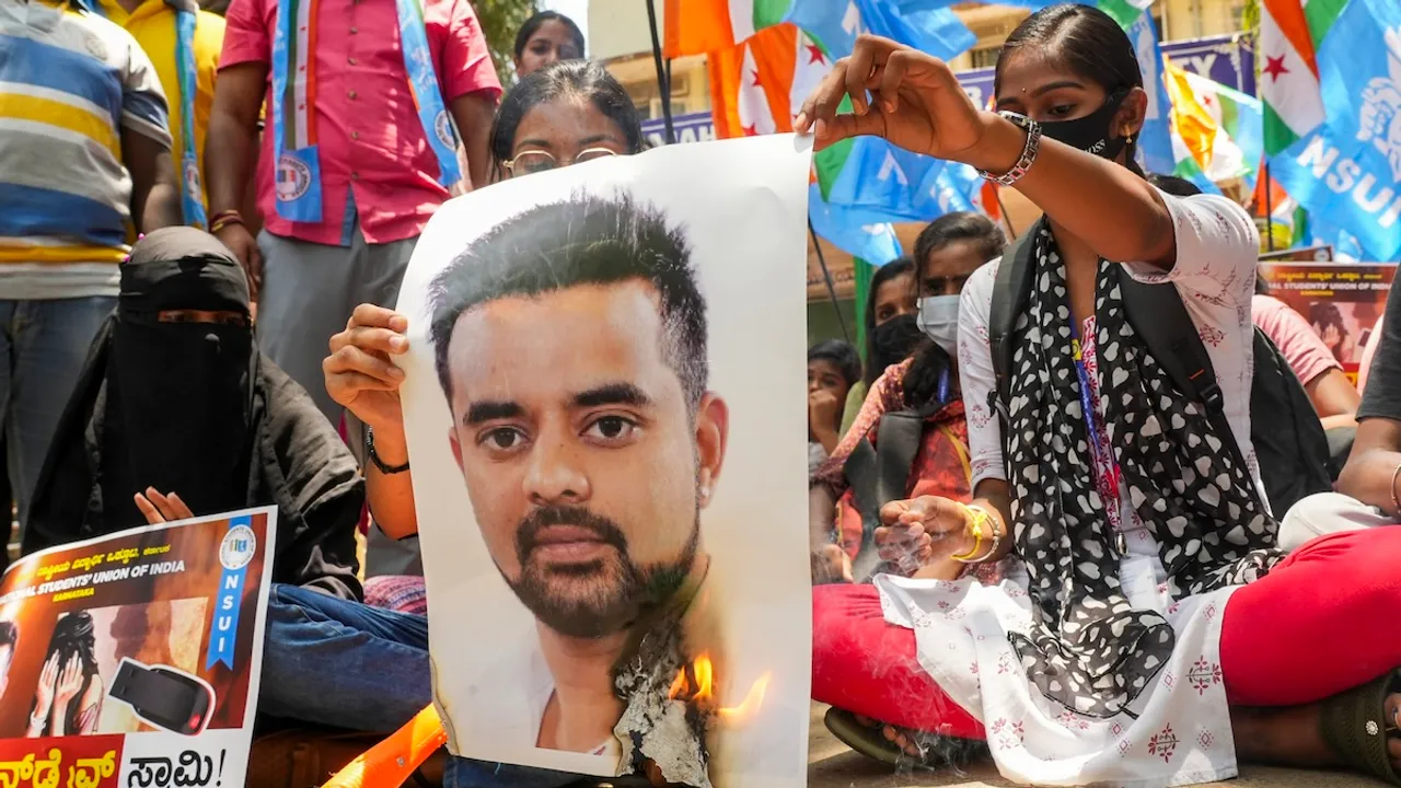 NSUI members burn a poster of JD(S) MP Prajwal Revanna during a protest against his involvement in the alleged sexual abuse case, in Bengaluru, Tuesday, April 30, 2024