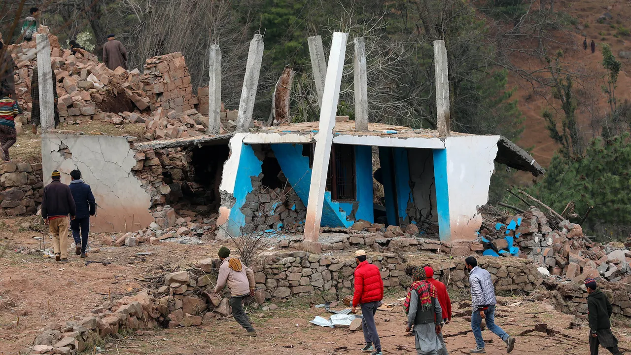 People move out of the spot after a lanslide that damaged several houses, at Duksar Dal in Ramban district on Monday