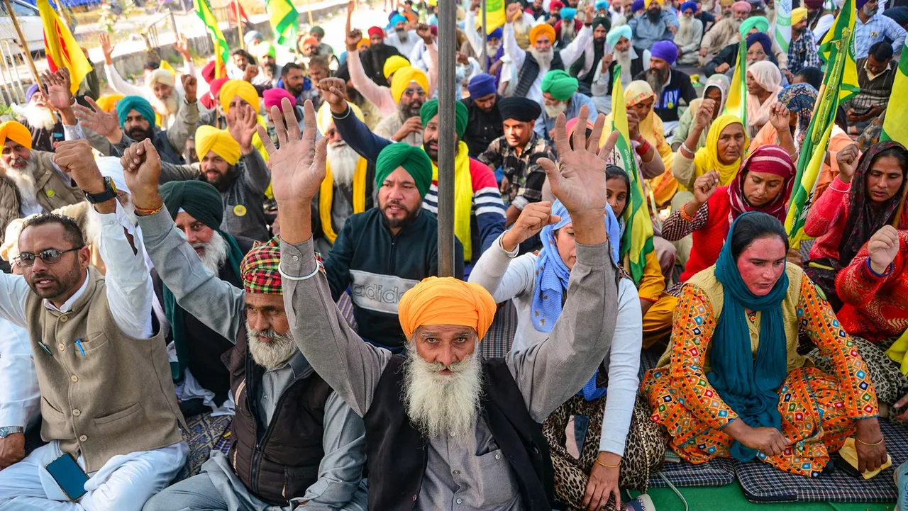Farmers shout slogans as they block a National highway during a protest demanding an increase in sugarcane prices among other demands, in Jalandhar