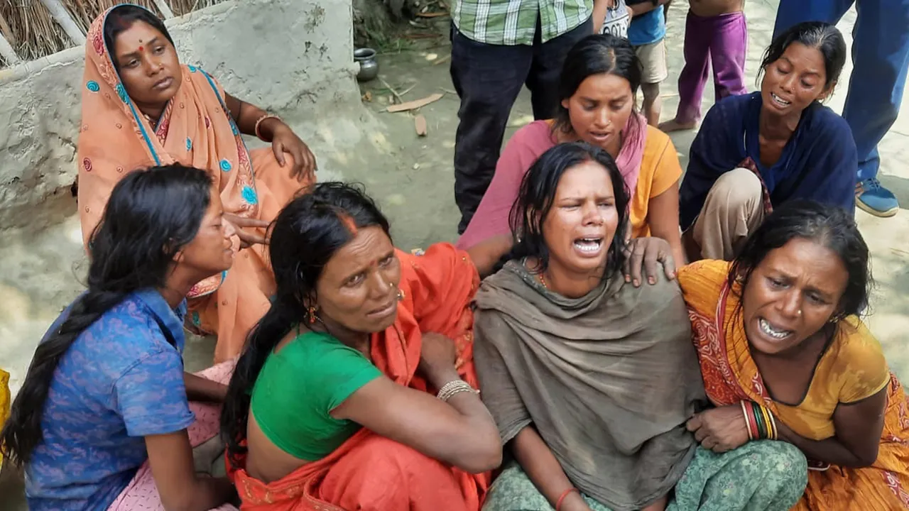Relatives of victims mourn after at least fourteen persons died and 10 others were hospitalised after allegedly consuming suspected spurious liquor in Motihari on April 16