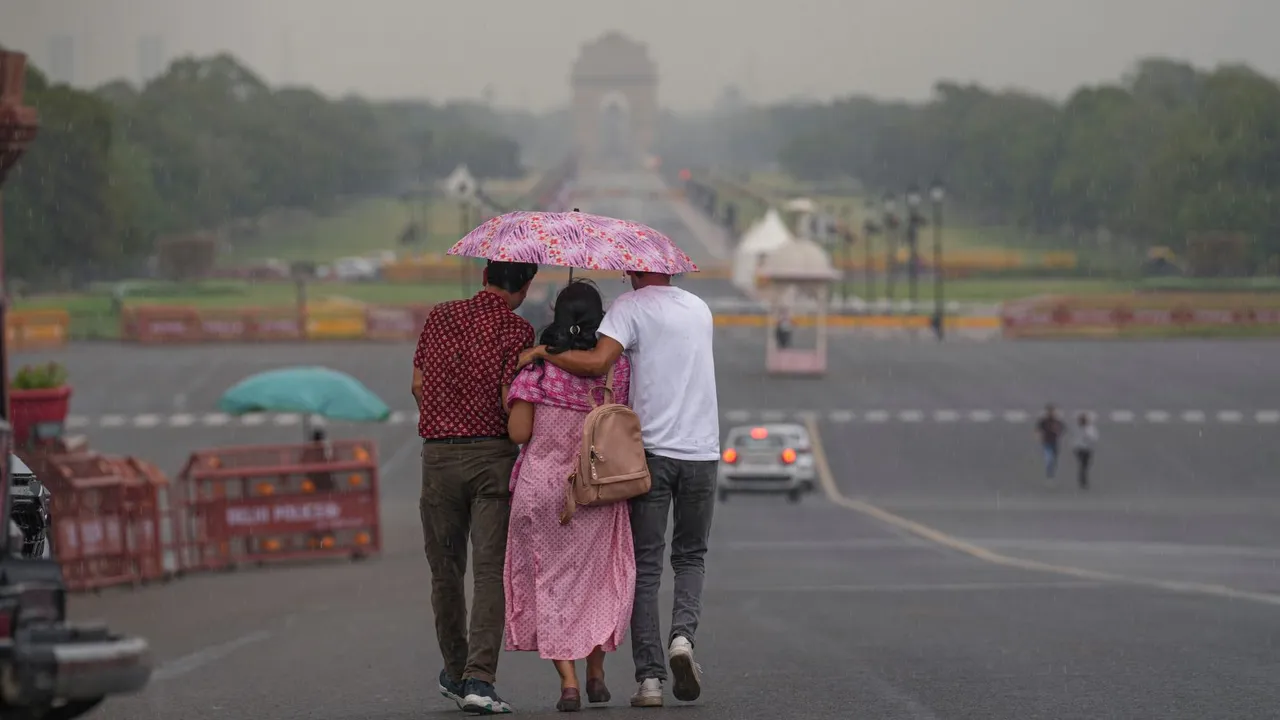 Three people share an umbrella as they walk down the Kartavya Path amid rains, in New Delhi, Friday, June 21, 2024.