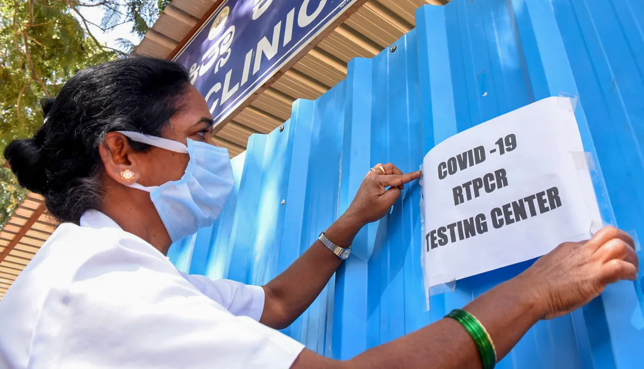 A medic puts up a notice at a Covid-19 testing centre of the district hospital after cases of COVID-19 sub-variant JN.1 were detected in the country, in Chikkamagaluru district
