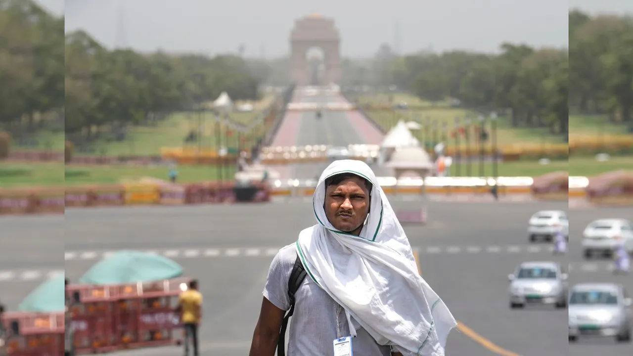 A man covers his head for protection from the scorching sun on a hot summer day, in New Delhi.