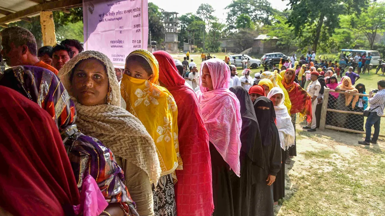 Voters wait in a queue at a polling station to cast their votes for the second phase of Lok Sabha elections, in Morigaon district, Assam, Friday, April 26, 2024.