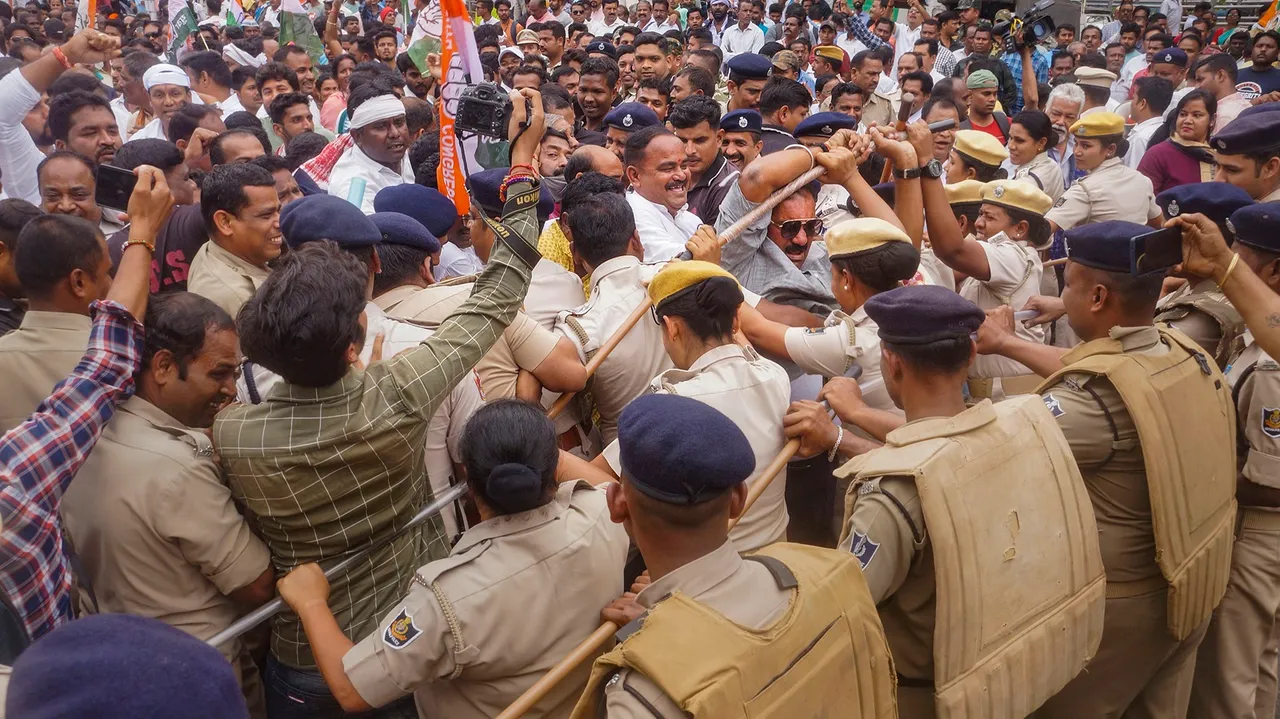 Police personnel try to stop Congress workers during a protest march against the Odisha government over alleged corruption in the government, in Bhubaneswar