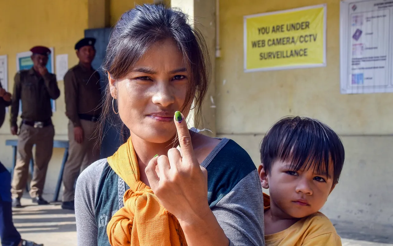 A voter shows her finger marked with indelible ink after casting her vote for Mizoram Assembly elections, in Mamit district