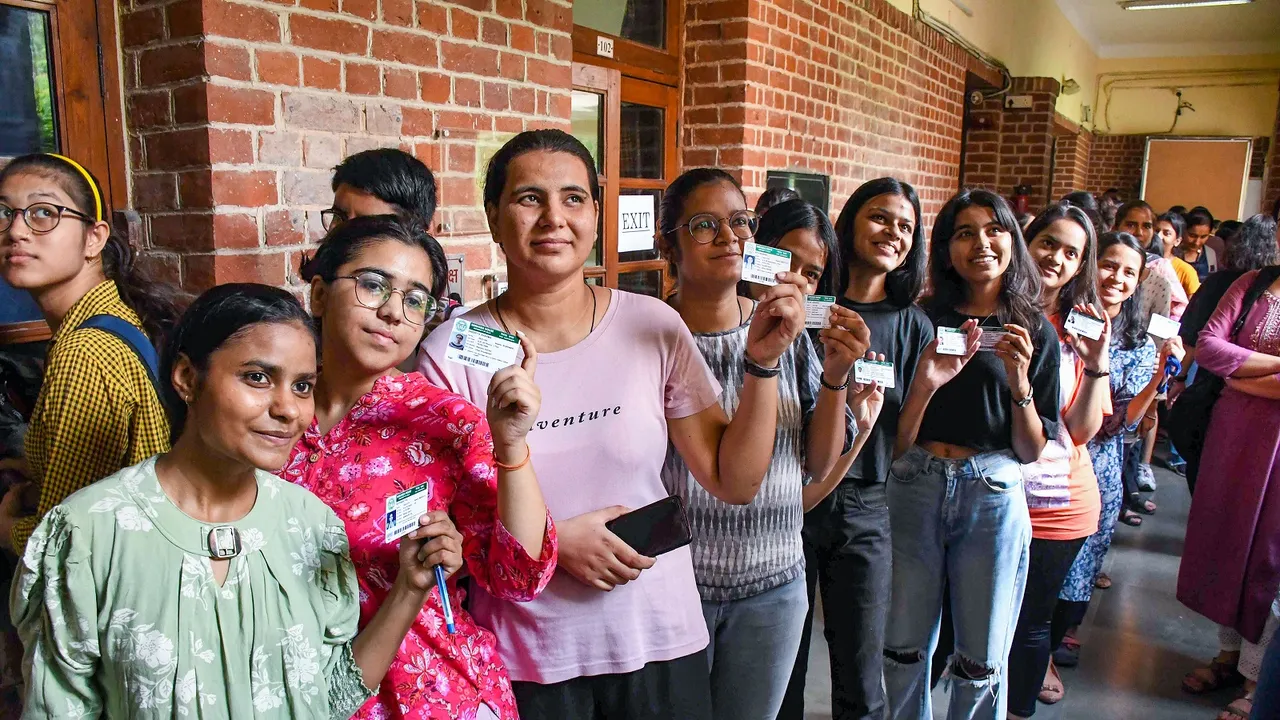Students show their identification cards as they arrive to cast their votes for the Delhi University Students' Union (DUSU) polls 2023, at Miranda House college in New Delhi
