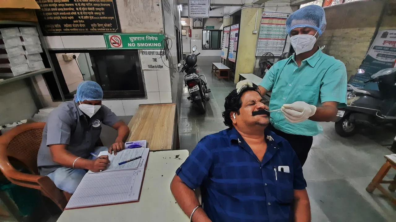 Health officials perform COVID-19 test on a man at the Municipal Corporation Hospital, in Thane