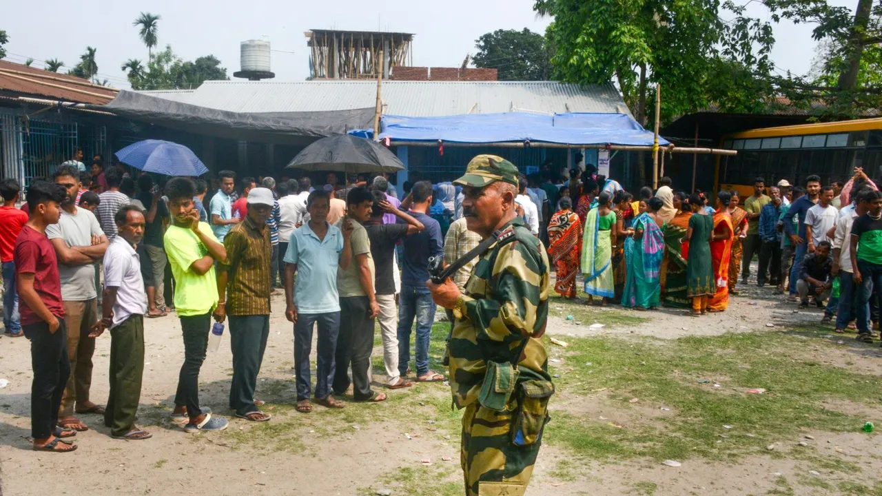 A security personnel stands guard as voters wait in a queue at a polling station to cast their votes for the first phase of Lok Sabha elections, in Jalpaiguri, Friday, April 19, 2024