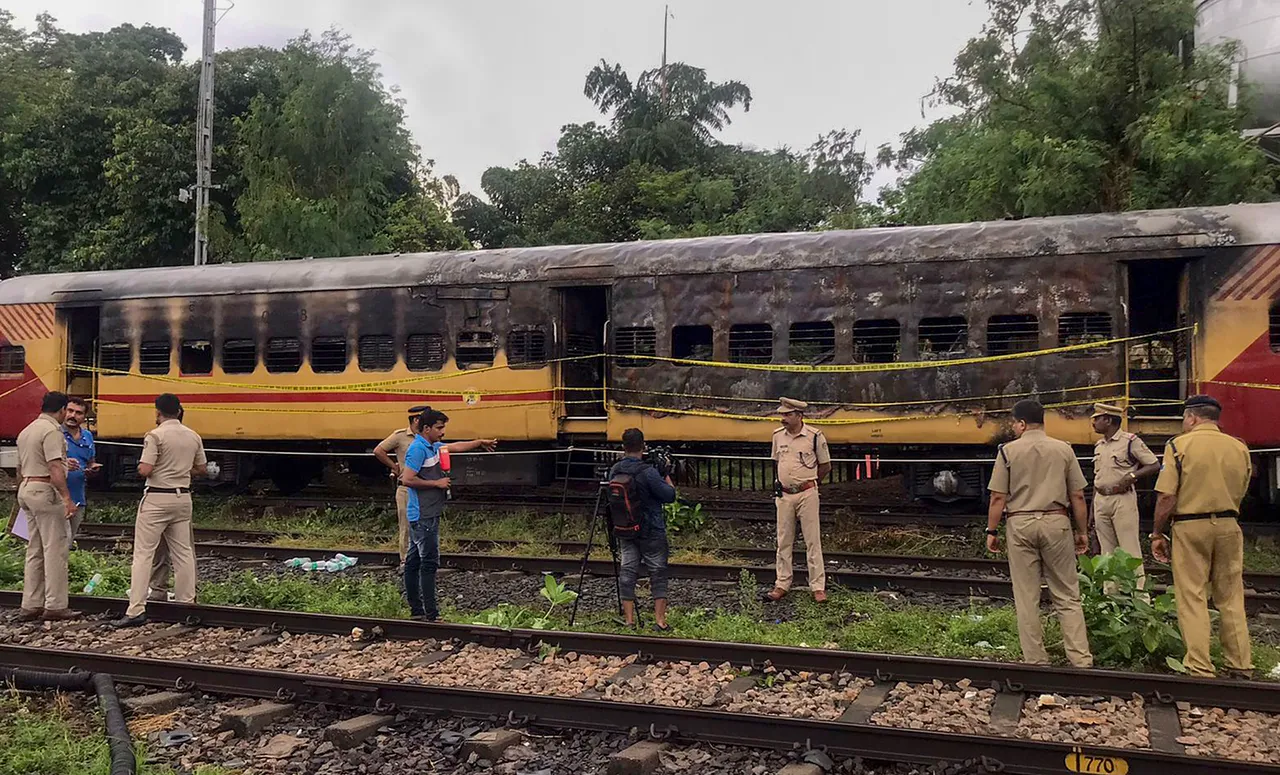 Police personnel inspect the Alappuzha-Kannur Executive Express train which caught fire, at a railway station in Kannur