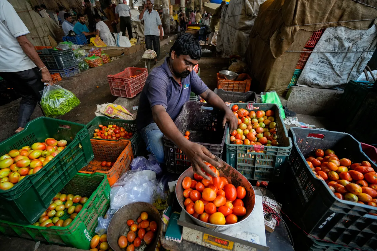 A vendor sorts tomatoes at Azadpur Mandi, in New Delhi
