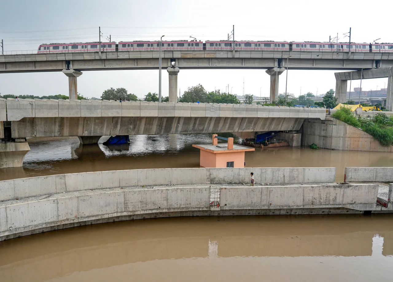 A Delhi Metro train passes above the floodwaters of the swollen Yamuna river at Mayur Vihar, in New Delhi