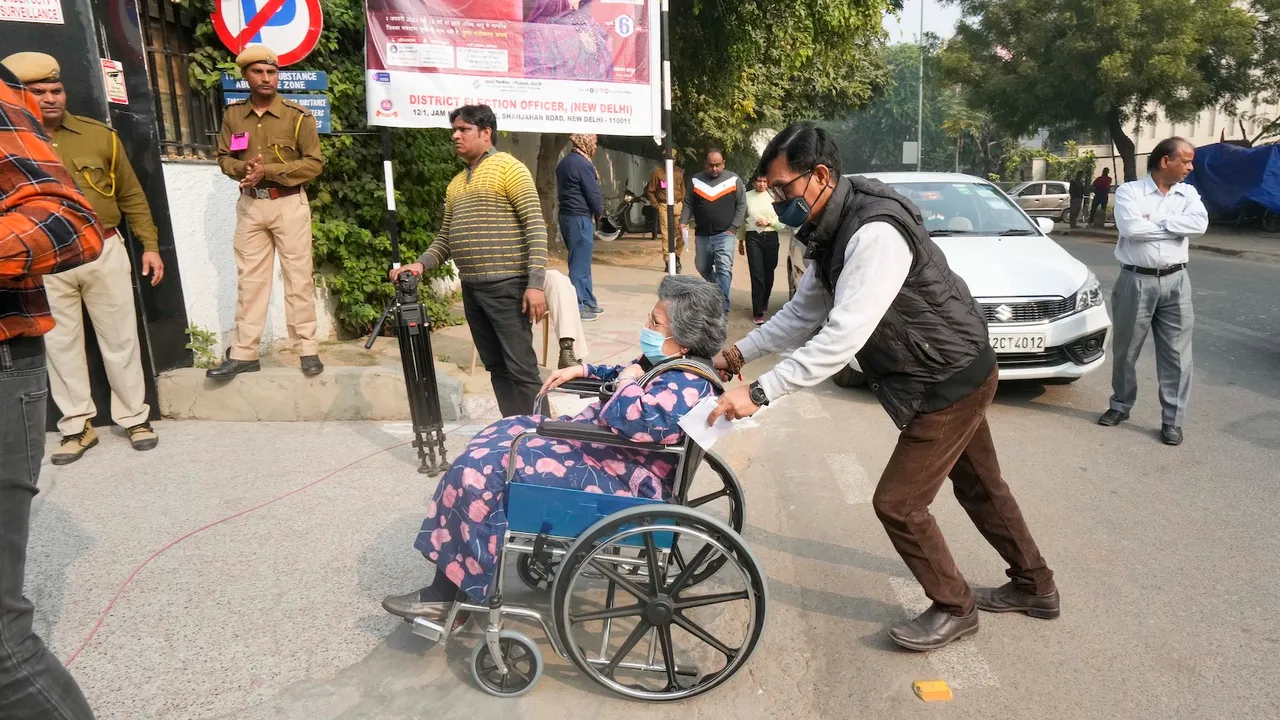 A wheelchair bound voter arrives to cast her vote for the MCD elections