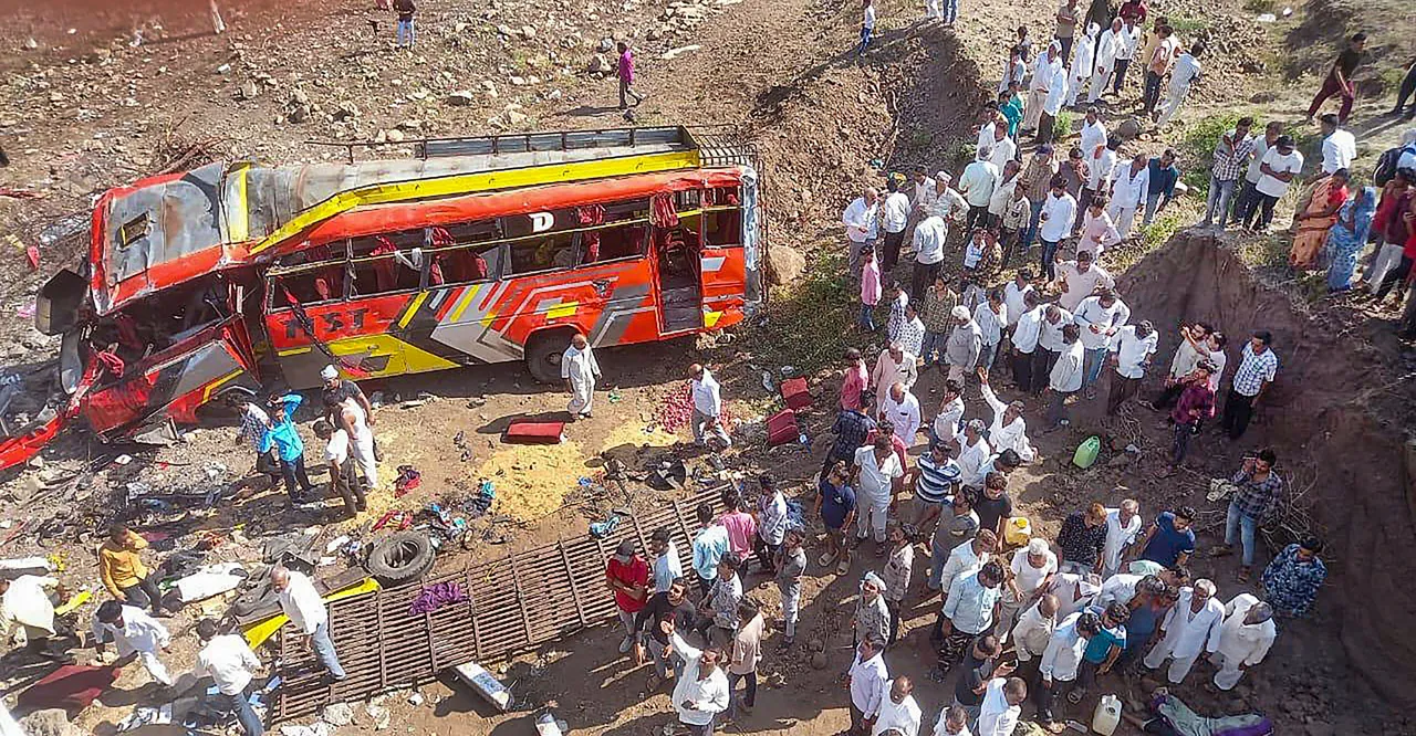 Locals gather at the site after a bus fell from a bridge in Madhya Pradesh's Khargone district