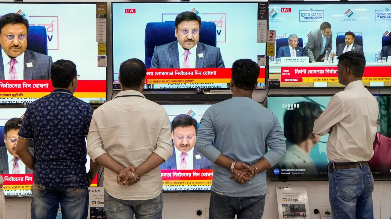 People watch live telecast of the Election Commission of India's press conference for the announcement of the schedule of Lok Sabha elections, at a TV showroom in Kolkata