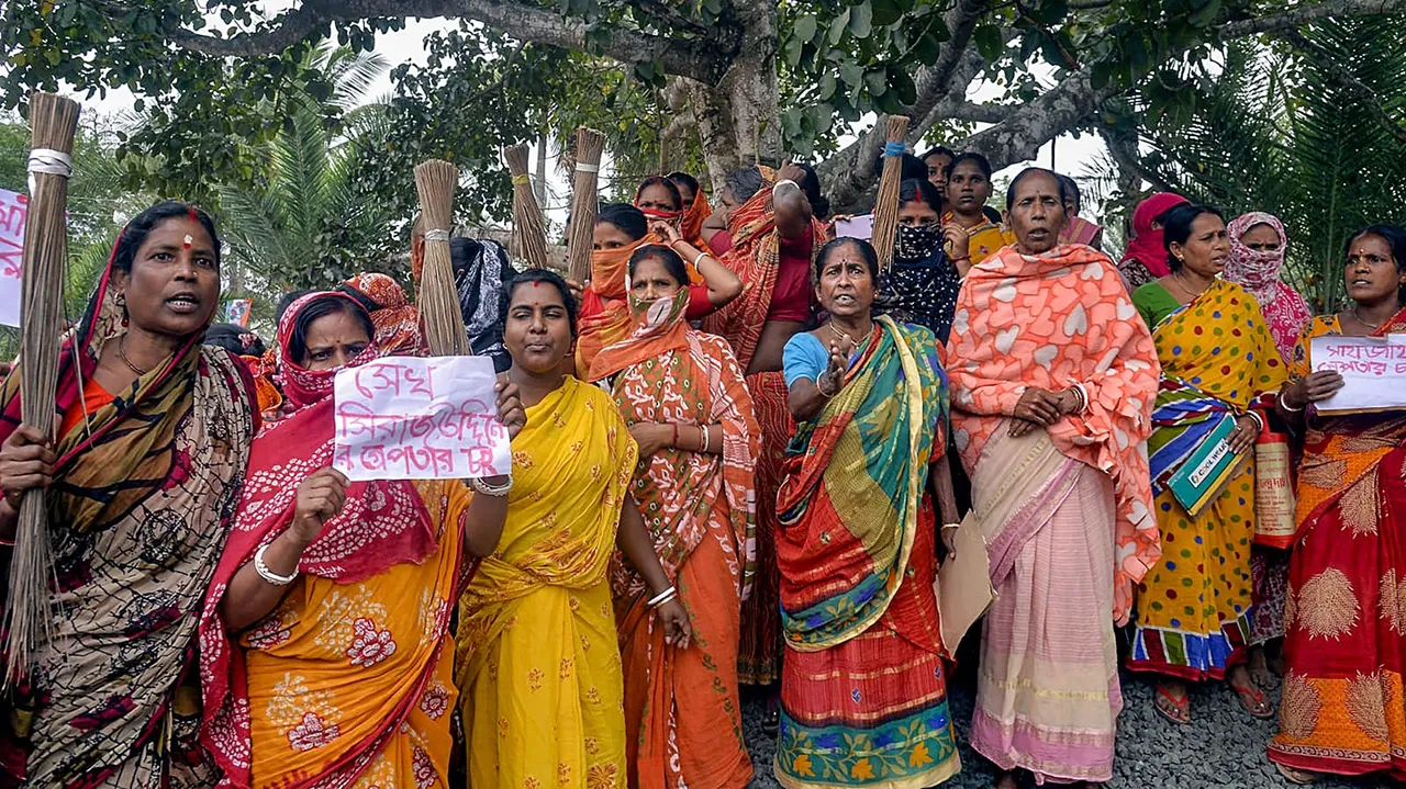 Women holding posters stage a protest demanding the arrest of local TMC leaders over Sandeshkhali incident allegations, in North 24 Parganas district