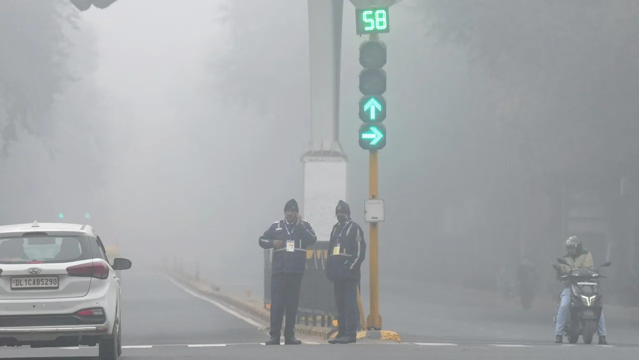 Traffic police personnel during a cold and foggy winter morning, in New Delhi