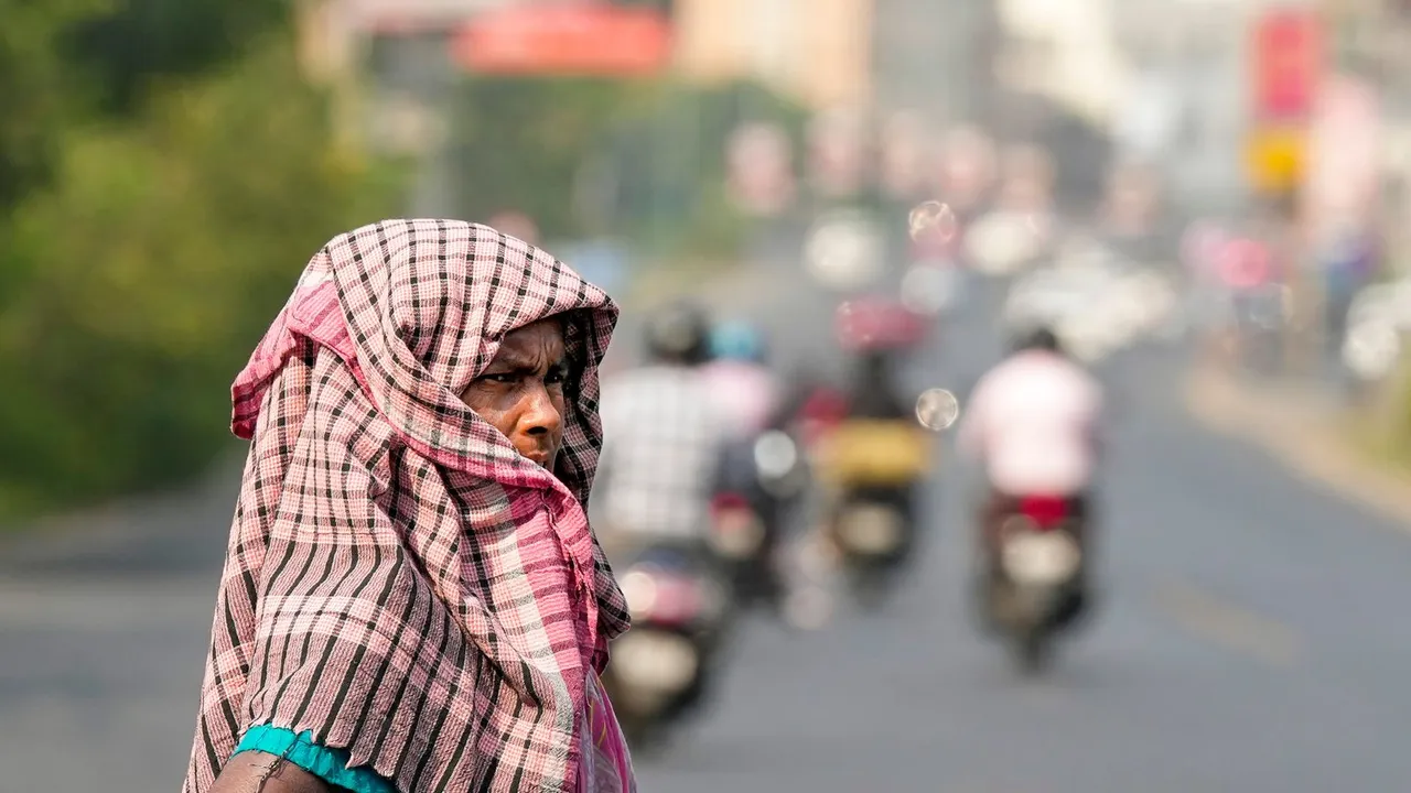 A woman covers her head for protection against the scorching sun on a hot summer day